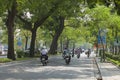 Vehicles traveling on a green street of Hanoi capital