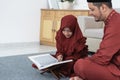 Veil girl learns the Al-Quran with her father