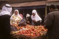 Veiled arab women buy apples in a street market