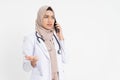 veiled female doctor wearing a white uniform is shocked while making a phone call with space