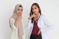 veiled female patient with pointing gesture and beautiful doctor in white uniform holding chin with expression thinking Royalty Free Stock Photo