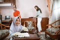 veiled girl smiling with thumbs up while wiping table