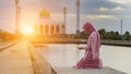 Veiled Islamic woman wearing a burka standing in a beam of overhead light in atmospheric darkness