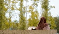 veiled muslim mother on her back with her baby in the park. Spanish migration