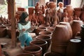 Veiled woman holding clipboard while counting pottery ceramics