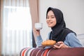 veiled woman smiling while having breakfast sitting on the bed Royalty Free Stock Photo