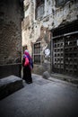 Veiled woman walking through a narrow street