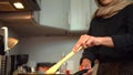 A veiled woman who is cooking in a modern kitchen