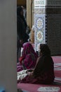Veiled women and children relax in the medresseh