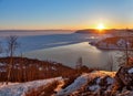 Veiw at Baikal lake at sunset with trees and rocks from a mountain peak in winter with snow Royalty Free Stock Photo