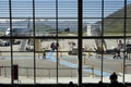 Veiw from inside Queenstown airport of passengers walking across runway from a Jetstar plane