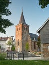 Velbert, Germany - August 23, 2021: Old Evangelical Church in the city center surrounded by flowers and greenery during sunset