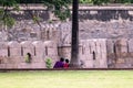 An Indian romantic couple sitting under a tree at the Vellore Fort park