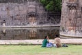 A young Indian couple sitting on the park outside the ancient Vellore fort