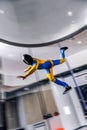 Velocity. Flight speed of skydiver. Parachutist in blue and yellow suit is in free fall. Extreme as a hobby.