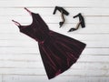 Velvet burgundy dress and shoes on wooden background. Fashionable concept Royalty Free Stock Photo