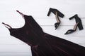 Velvet burgundy dress and shoes on wooden background. Fashionable concept Royalty Free Stock Photo