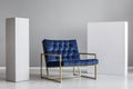 Velvet petrol blue armchair between two white blocks of wood