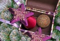 Velvet stars and Christmas balls in a casket on the background of the Christmas tree