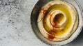 Velvety garleek hummus adorned with a swirl of olive oil and dusting of spices, served in a ceramic bowl on a speckled