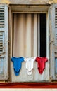 Open vintage French window shutters with drying laundry at Rue de lÃ¢â¬â¢Eveche street in medieval city of Vence in France Royalty Free Stock Photo