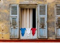 Open vintage French window shutters with drying laundry at Rue de lÃ¢â¬â¢Eveche street in medieval city of Vence in France Royalty Free Stock Photo