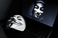 Vendetta mask on computeur with anonymous member on sreen . This mask is a well-known symbol for the online hacktivist Royalty Free Stock Photo