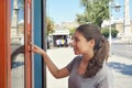 Vending machine. Attractive girl tanned buying drinks in summer. Young student or female tourist choosing a snack or drink at vend