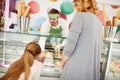 Vendor in confectionery serves girl with ice cream Royalty Free Stock Photo