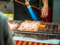 Vendor making giant Takoyaki with cheese using blowtorch to speed up the cooking. Royalty Free Stock Photo