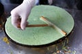 Vendor making spinach crepe outdoors