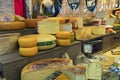 Vendor with many types of cheese on a street food market. Selection of various cheeses from cheese store