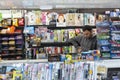 vendor of newspapers and magazines reads while waiting for customers