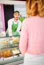 Vendor in pastry shop attending woman