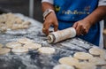 A vendor selling Padong Ko is kneading the dough to be fried and sold in a Thai roadside