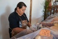 Vendor serving variety of traditional cheese in a cheese farm store