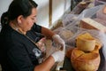 Vendor serving variety of traditional cheese in a cheese farm store