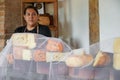 Vendor serving variety of traditional cheese in a cheese farm store