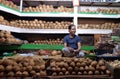 Vendor sits behind a large pile of coconuts in New Market in Kolkata