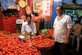 Vendor sits behind a large pile of tomatoes in New Market in Kolkata