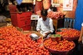 Vendor sits behind a large pile of tomatoes in New Market in Kolkata