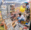 Vendor in stall of display insects for sale to tourists in floating markets