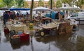 Vendors selling painting & second hand items at Vanves flea market on raining Saturday with water reflection in Paris, France