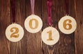 Veneer Christmas balls with numbers 2016 on a wood background Royalty Free Stock Photo