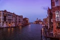 Venetian building at sunset time with lighting lights, boats and amazing sky over Grand canal. Royalty Free Stock Photo