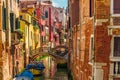 Venetian canal with boats and colorful facades of old medieval houses in Venice, Italy