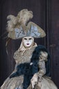 Venice Carnival figure in a colorful gold and grey costume and venetian mask Venice Italy Royalty Free Stock Photo