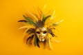 Venetian carnival yellow mask with feathers on bright yellow background. Masquerade mardi gras concept. banner, greeting card