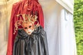 Venetian costume mask and red and black cloaks agains white background Royalty Free Stock Photo