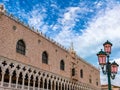 Venetian Doge's palace or Palazzo Ducale in Venice, Italy. Beautiful view of pink wall and arcade and clouds in blue sky Royalty Free Stock Photo